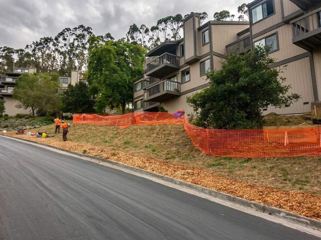 TrenchFree crew working near a multi-family housing property with safety fencing